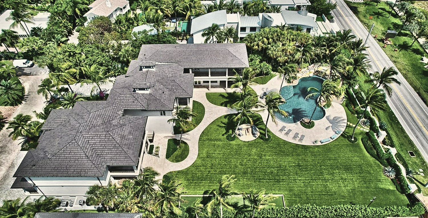 Aerial view of a large estate garden with pool and palms